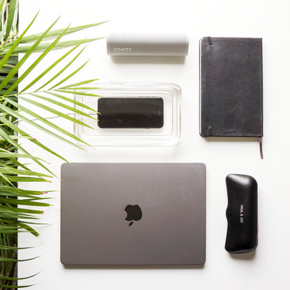 Stylish protective glass phone charging case amongst office essentials