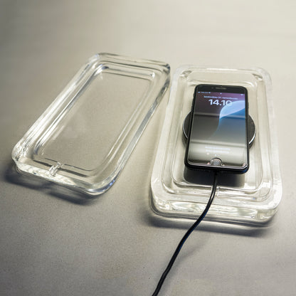 iphone on induction charger pad on a glass charging case